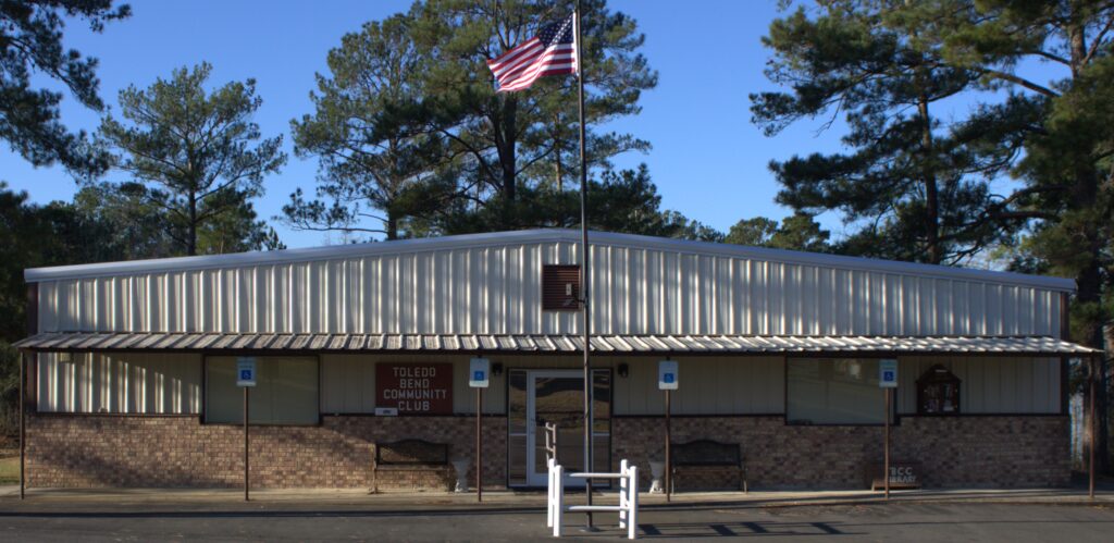 A building with an american flag flying in the background.